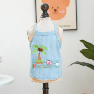 Light blue dog vest with coconut tree embroidery and orange wavy edges on a hanger