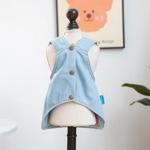 Detail van de lichtblauwe denim hondenjurk met drukknopen en een vintage badge-accent
