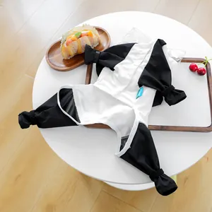 Nahaufnahme des schwarz-weißen Panda-Haustier-Schlafanzugs mit Druckknöpfen und blauem Logo