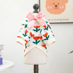 Detail of pet knit sweater featuring tulip patterns, pink bow, and white lace trim
