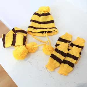 Detail van geel en bruin gestreepte set met gebreide muts, sjaal en beenwarmers