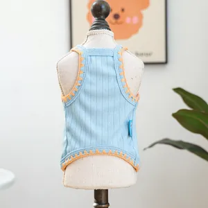 Detailed knit texture of blue pet vest with orange scalloped edges on white mannequin