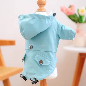 Detail of light blue waterproof pet raincoat with hood, drawstrings and side pockets