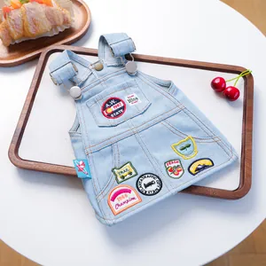 Retro denim huisdierjurk met vintage patches en metalen gespen op houten dienblad