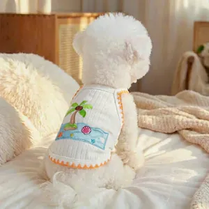 Detail of pet vest featuring tropical palm tree embroidery and orange wavy trim edges
