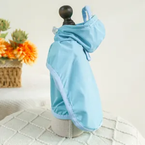 Detail of light blue waterproof pet raincoat featuring a hood and drawstring on model