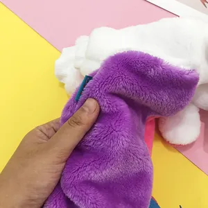 Detail of plush rainbow pet coat fabric showing soft purple and pink velvet material