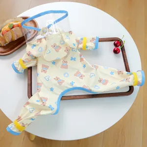 Detail of waterproof dog raincoat with bear prints, clear face shield and velcro cuffs