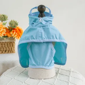 Detail of light blue pet raincoat featuring a transparent hood brim and adjustable drawstring