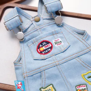 Macro detail van vintage hondendenim jurk met retro geborduurde badges en metalen gespen