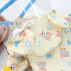 Close-up of waterproof yellow pet raincoat with bear prints and transparent face shield