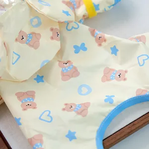 Close-up of cute bear and heart pattern on yellow waterproof dog raincoat fabric