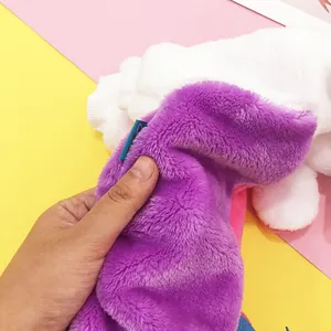 Detail of soft purple and white faux fur pet apparel with blue woven label texture