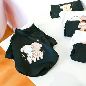 Close-up of black cotton pet T-shirt with cute cartoon dogs and stars on soft fabric