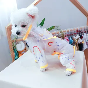 Detail of transparent rainbow pet raincoat with yellow trim on a small white dog