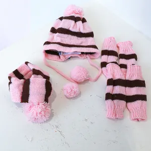 Detailoverzicht van gebreide hondenmuts, sjaal en beenwarmers met roze-bruine strepen