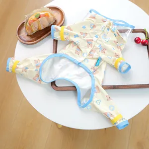 Detail of a yellow waterproof pet raincoat featuring cute bear prints and a transparent hood