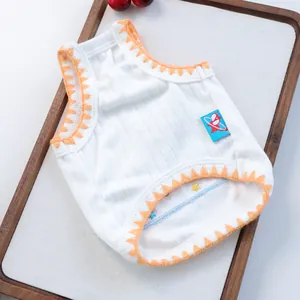 Detail of white ribbed pet vest featuring orange zigzag trim and a blue cartoon tag