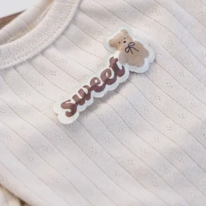 Detailaufnahme des gerippten Haustier-Strickpullovers mit Teddybär-Stickerei und Text