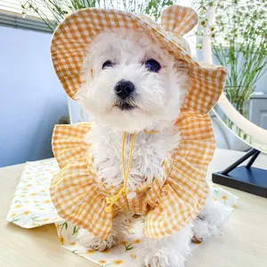 Detail of yellow plaid pet sun hat with ear holes and matching ruffled dog shirt