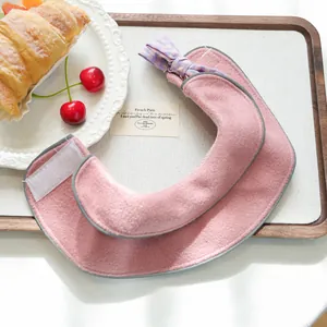 Dettaglio della mantella rosa per animali con fiocco a scacchi viola e velcro