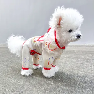 Close-up of a white Bichon wearing a red rainbow waterproof pet jumpsuit raincoat