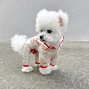 Detail of waterproof pet raincoat featuring rainbow prints and red elastic cuffs
