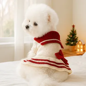 Detail of knitted pet sweater with sailor collar and red bow on a white dog