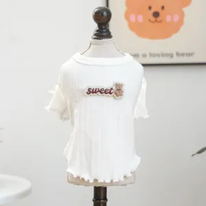 Detail des weißen Rippstrick-Haustierpullovers mit Bären-Patch und gewelltem Saum