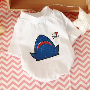 Detail of white cotton pet T-shirt with shark print and red heart on striped background