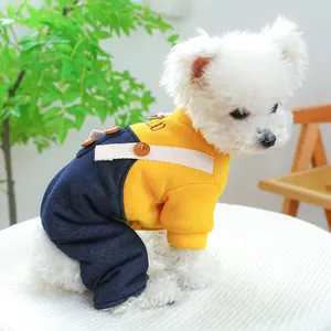 Detail of yellow and denim pet jumpsuit with letter embroidery on white dog