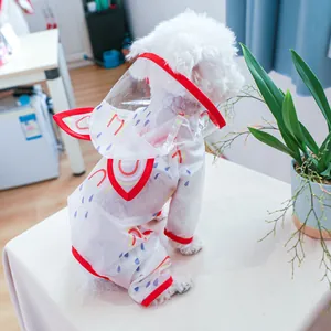 Detail of waterproof pet raincoat with rainbow print and red edges on a white dog