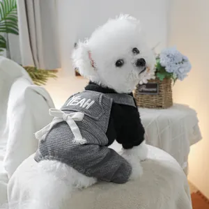 Detail of grey waffle knit pet overalls with white bow and YEAH embroidery on small dog