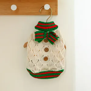 Detail view of pet knit sweater with wooden buttons and holiday bow on hanger