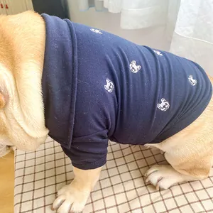 Détail du polo pour chien bleu marine avec broderies de têtes de bouledogue français blanc