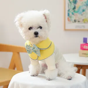 Dettaglio di uno scialle per animali con fiocco a quadri blu e giallo su cane