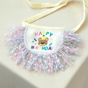 Detail of dog birthday bandana with bear embroidery and colorful tassel fringe