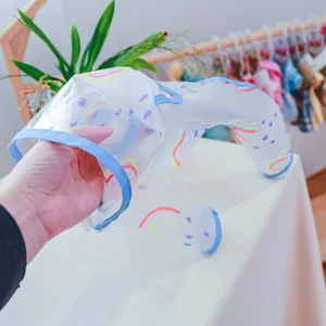 Detail of transparent pet raincoat with rainbow prints and blue edges for small dogs