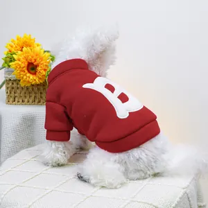 Detalle de sudadera roja para perro con parche de letra B blanca y puños elásticos