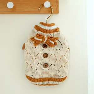 Detail of pet knit sweater showing wooden buttons, bow tie, and hollow knitting texture