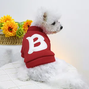 Detalle de sudadera roja para mascota con bordado de letra B blanca en perro