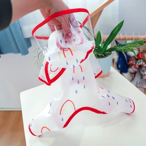 Detail of waterproof pet raincoat featuring transparent hood and rainbow pattern prints