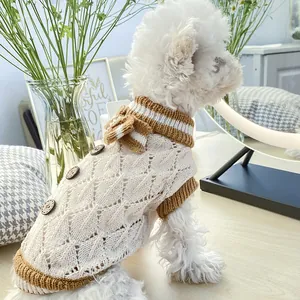 Detailed knit texture and wooden buttons on a cream British style dog sweater vest