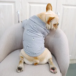 Polo gris pour bouledogue français avec broderie intégrale sur un canapé douillet