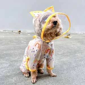 Detail of waterproof dog raincoat with rainbow print and yellow trim on brown poodle