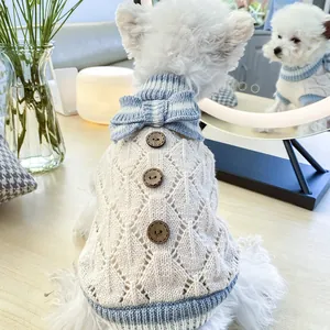 Detail of pet knit sweater with hollow diamond pattern, blue bow and wooden buttons