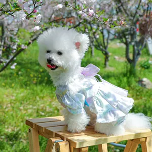Detailed view of white tulle pet dress with purple bows on a small dog in a park
