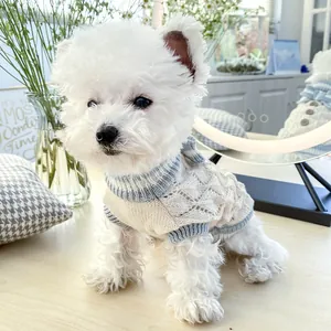 Close-up of cable knit pet sweater featuring wood buttons and blue striped collar detail