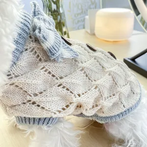 Detail of hollow knit texture on pet sweater with bow and button accents
