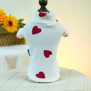 Detail of white rib-knit pet sweater featuring red heart patterns and high-collar design